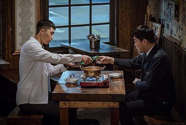 聚餐男子轉身遮口飲酒。